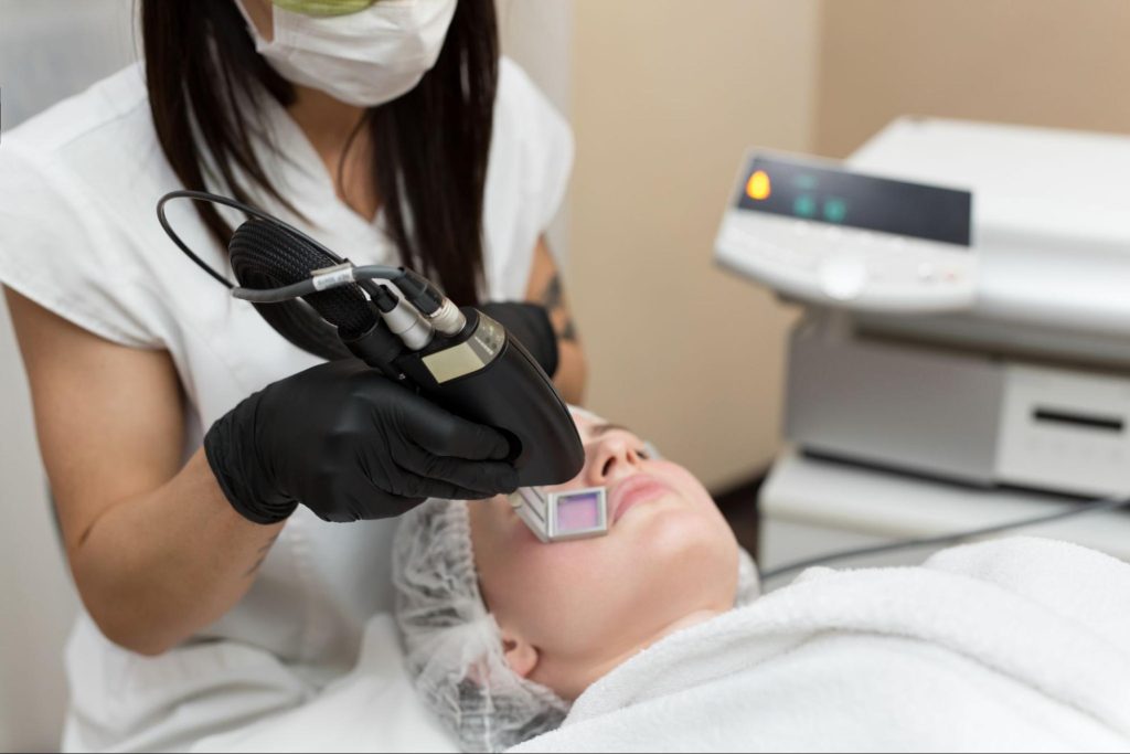 A patient undergoing a non-surgical skin tightening procedure by a cosmetologist.