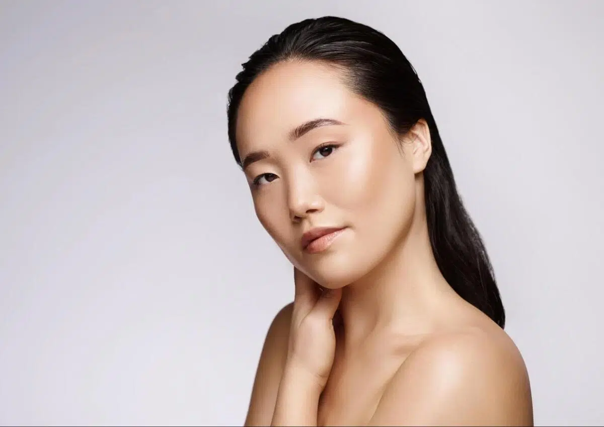 Young Asian woman with firm, tightened skin showcasing non-surgical facelift results
