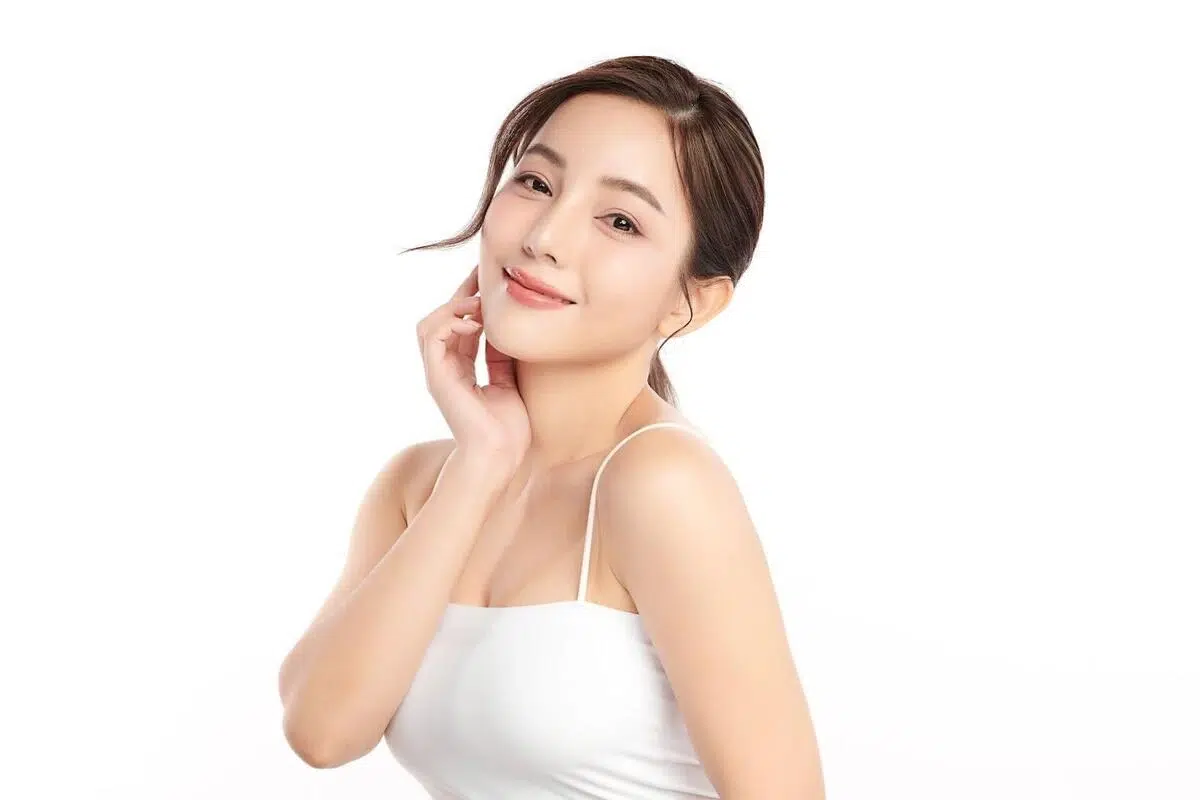 A woman holding her smooth cheek A woman with youthful and smooth skin